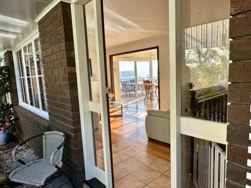 a house with a porch with a chair and a balcony at Secluded Oasis with Water Views in Sandy Bay