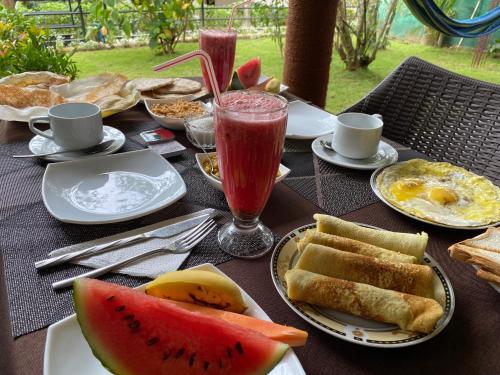 a table with plates of food and fruit on it at Alone Cage Ella in Ella