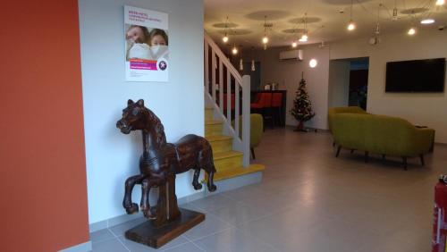 a statue of a horse in a room with a staircase at Parc Hôtel Pompadour in Arnac-Pompadour