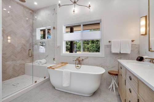 un bagno bianco con vasca e doccia di Private Farmhouse on 4 acres w Pool Hot Tub a Sonoma