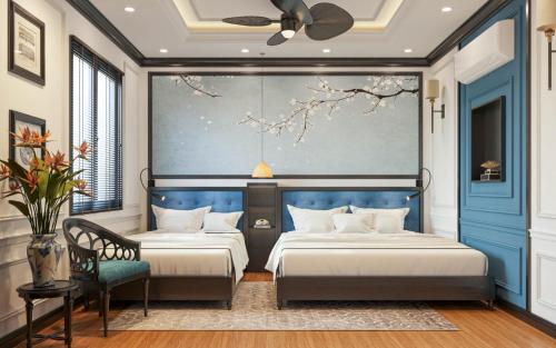a bedroom with two beds and a blue wall at Thuy Duong Boutique Hotel Hue in Hue