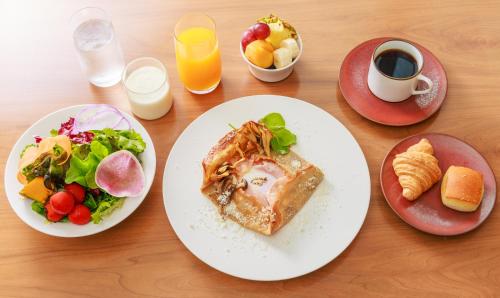 a wooden table topped with plates of food and drinks at NOHGA HOTEL UENO TOKYO in Tokyo