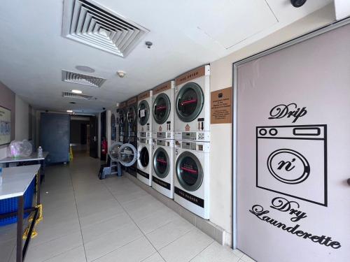a laundry room with multiple washing machines on the wall at Resort Suites By Newcityhome in Petaling Jaya