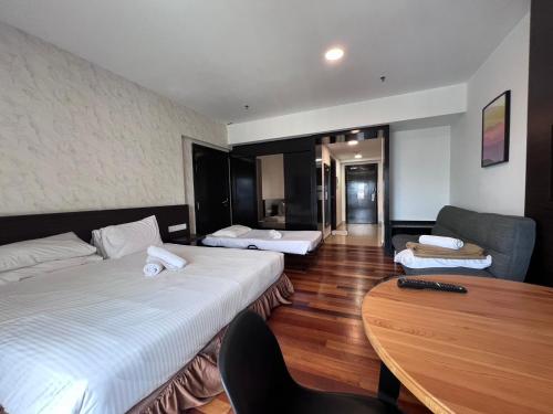 a hotel room with two beds and a table at Resort Suites By Newcityhome in Petaling Jaya