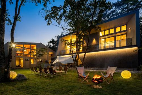 白马村Hakuba Amber Resort by Jade Group的一群椅子和一火炉在建筑物前