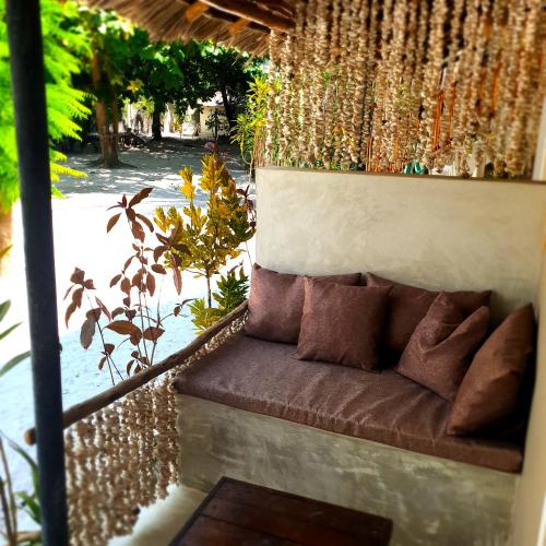 a brown couch sitting under a pergola at Michamvi Spirit Lodge in Michamvi