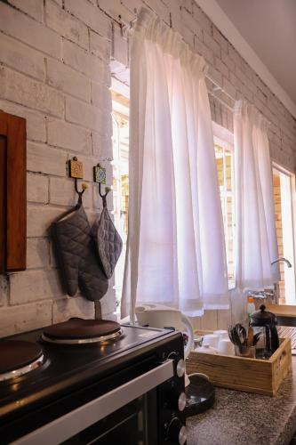 a kitchen with white brick walls and a stove at Rooiberg View Clarens in Clarens