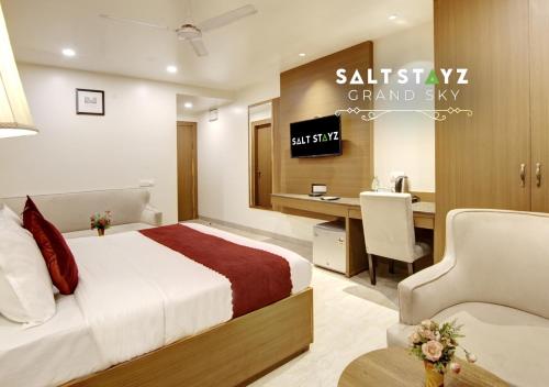 a bedroom with a bed and a desk with a computer at Saltstayz Select - Unitech Cyber Park & Sector 39 in Gurgaon