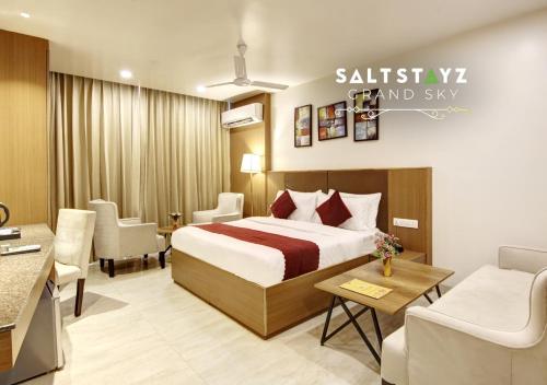 a hotel room with a bed and a living room at Saltstayz Select - Unitech Cyber Park & Sector 39 in Gurgaon