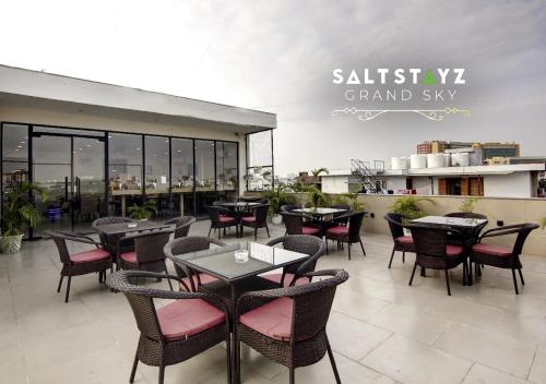a restaurant with tables and chairs on a patio at Saltstayz Select - Unitech Cyber Park & Sector 39 in Gurgaon