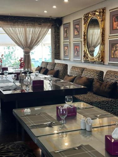 a restaurant with couches and tables with wine glasses at 2 BHK 18 Hole Golf Course view By Goldfinch in Islamabad