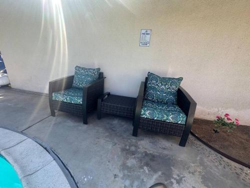 two chairs with pillows sitting on a patio at 4 Bedroom King Beds One-Story Tesla EV in Riverside