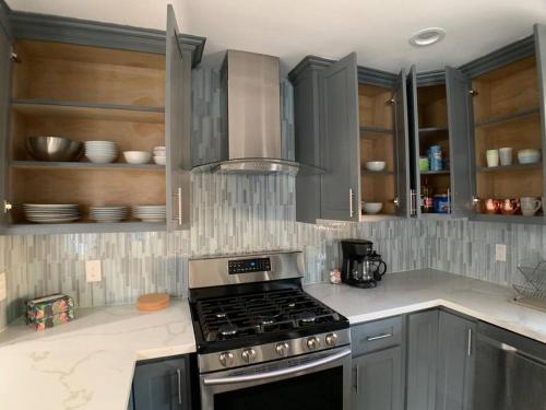 a kitchen with gray cabinets and a stove top oven at 4 Bedroom King Beds One-Story Tesla EV in Riverside