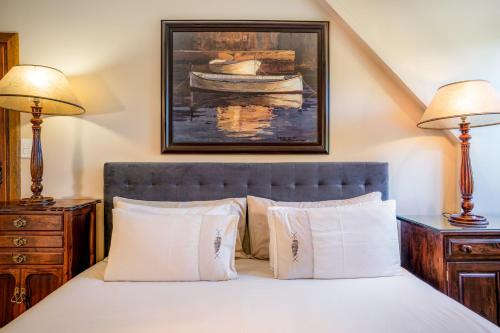 a bedroom with a bed with two lamps and a painting of a boat at Avemore Island Home- full power back up-magical views in Sedgefield