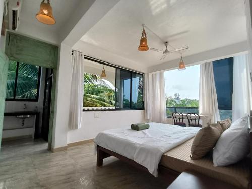 a bedroom with a bed and a large window at NAMAKA, Morjim and Ashwem Beach 300m away in Morjim