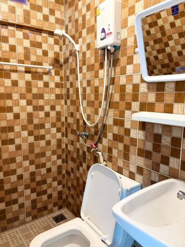 a bathroom with a shower and a toilet and a sink at LSN Mansion in Bangkok