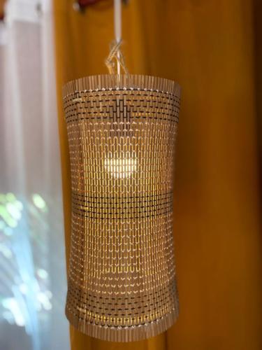 a brown wicker chandelier hanging from a wall at Alfonsa Tent Ground - Camp By The Sea in Oslob