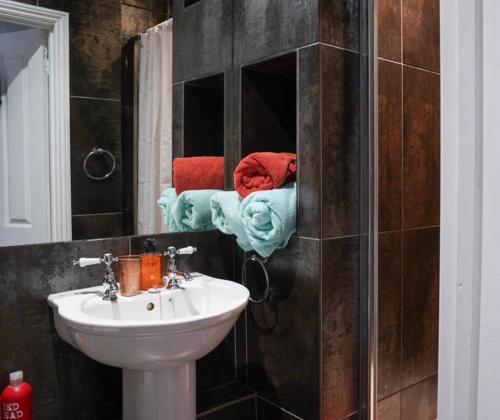 a bathroom with a sink and a shower with a mirror at Stamford Lodge in Stamford