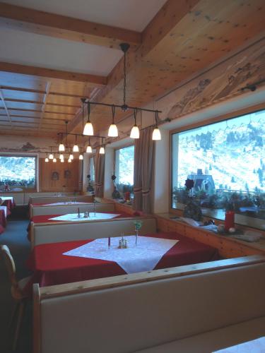 a dining room with a row of tables and chairs at Gasthof Geierwallihof Klotz Konrad KEG in Vent