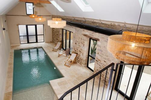 une vue aérienne d'une piscine dans un immeuble dans l'établissement LE DOMAINE DE SOANI - Piscine intérieure, Jacuzzis & Sauna ADULT ONLY, à Saint-Évarzec