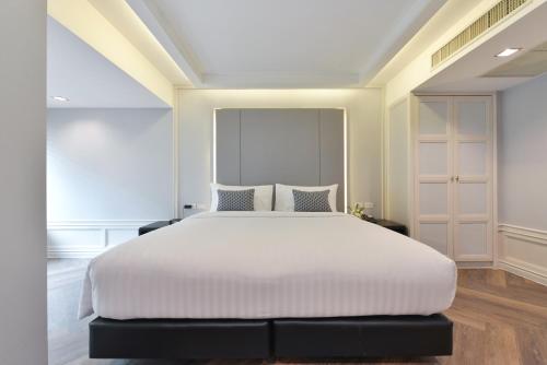 a bedroom with a large bed with white sheets at Centre Point Sukhumvit Thong-Lo in Bangkok