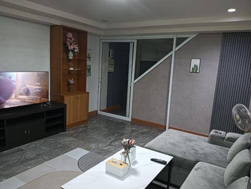 a living room with a couch and a tv at Ben House Hatyai in Hat Yai