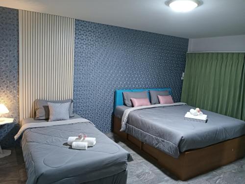 a bedroom with two beds with towels on them at Ben House Hatyai in Hat Yai