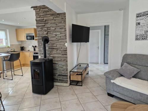 un salon avec une cheminée et un canapé dans l'établissement Chez Katy, à Ban-sur-Meurthe-Clefcy