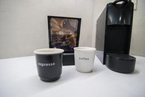 two coffee cups sitting on a table next to a laptop at Argolis Stone Homes in Kranidi