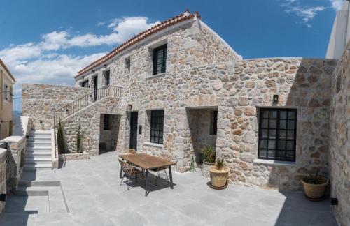 a stone building with a table in front of it at Argolis Stone Homes in Kranidi