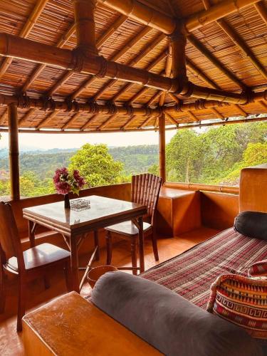 a living room with a table and chairs and a view at Phu Chaisai Chiang Rai Mountain Resort in Mae Salong Nai