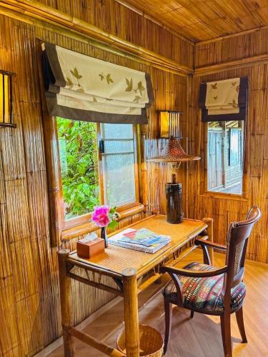 a room with a wooden table and chairs and a window at Phu Chaisai Chiang Rai Mountain Resort in Mae Salong Nai