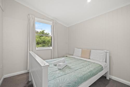 KarraganbahにあるFamily Retreatのベッドと窓のある白い寝室