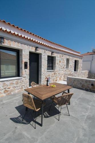 a wooden table and chairs on a patio at Argolis Stone Homes in Kranidi