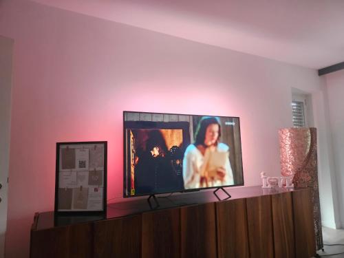 a flat screen tv sitting on top of a cabinet at Residence Moai - Exklusiver Rückzugsort für Geschäftsreisen - kostenloser Parkplatz, WLAN, Waschtrockner, Smart TV, Qbo ESSENTIAL, ergonomischer Schreibtisch in Erlangen