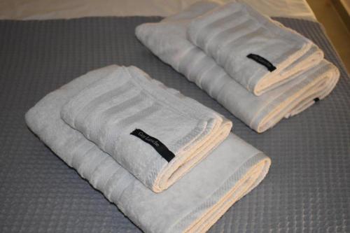 three towels sitting on top of a bed at Argolis Stone Homes in Kranidi