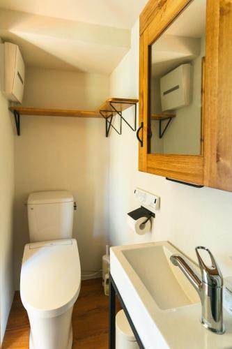 a bathroom with a toilet and a sink at ザ ノマド 八ヶ岳 in Hokuto