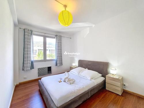 a bedroom with a bed with white sheets and a window at Tourette - appartement proche du centre-ville - Saint-Denis in Saint-Denis