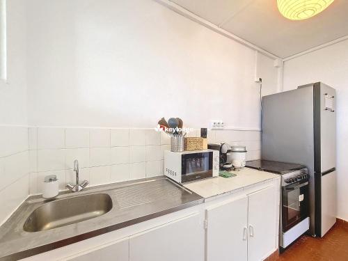 a kitchen with a sink and a refrigerator at Tourette - appartement proche du centre-ville - Saint-Denis in Saint-Denis