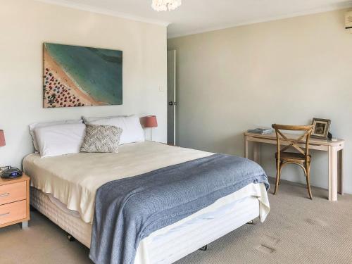 a bedroom with a bed and a table and a desk at Greenpark #10 in Avoca Beach