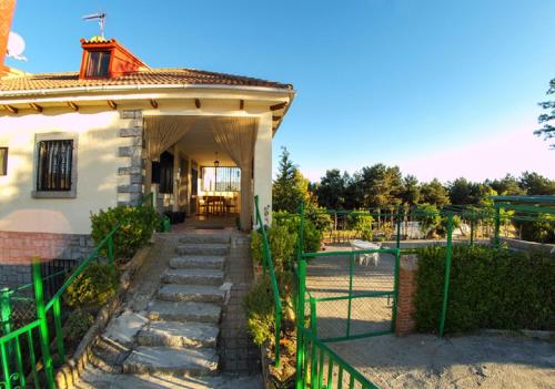 una casa con una valla verde y un patio en El Mirador de Tortoles, en Tórtoles