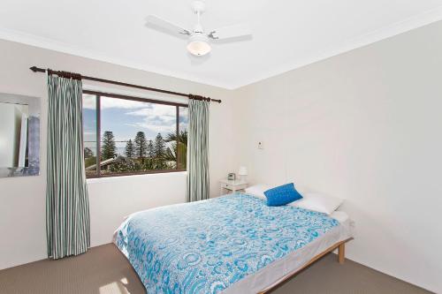 a bedroom with a bed and a window at Uralba #17 in Terrigal