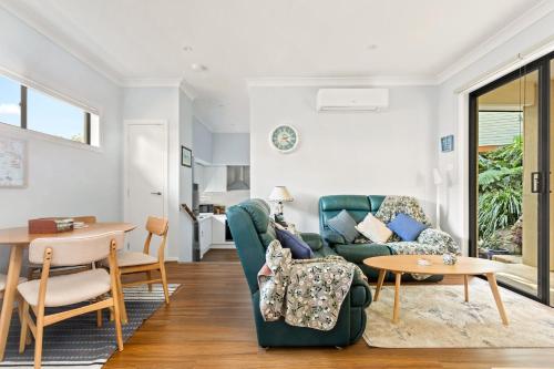 a living room with a couch and a table at Bea's Cottage in Clontarf in Sydney