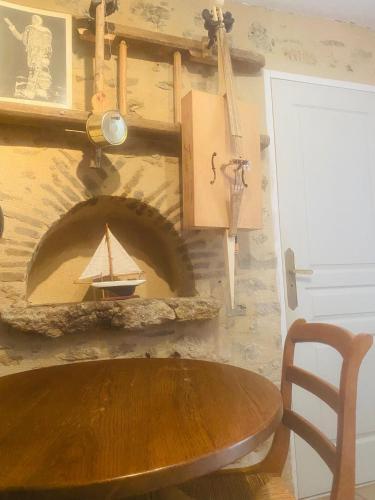 - une table en bois dans une chambre avec cheminée dans l'établissement Charmante petite maison pour deux, à Badecon-le-Pin