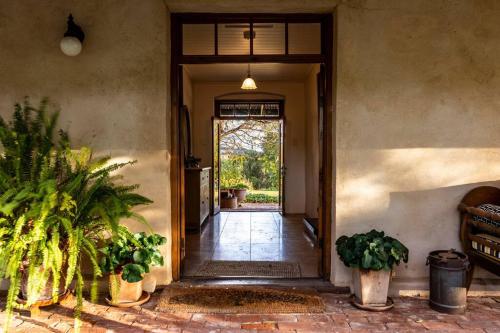 einen Eingang zu einem Haus mit Topfpflanzen und einer Tür in der Unterkunft Seppeltsfield Vineyard Cottage Luxury Romantic Getaway in Seppeltsfield