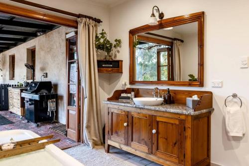 ein Badezimmer mit Waschbecken und Spiegel in der Unterkunft Seppeltsfield Vineyard Cottage Luxury Romantic Getaway in Seppeltsfield