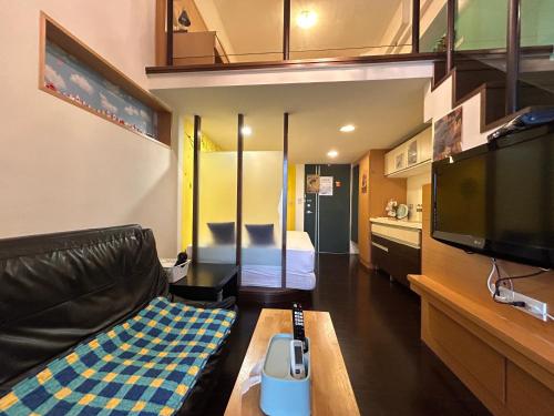 a living room with a couch and a tv at Rihe Hot spring B&B in Jiaoxi