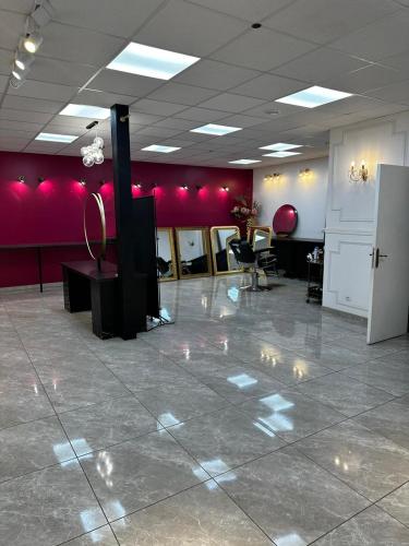 Cette chambre est dotée de murs rouges, de tables et de chaises. dans l'établissement Fbacademy, à Vénissieux