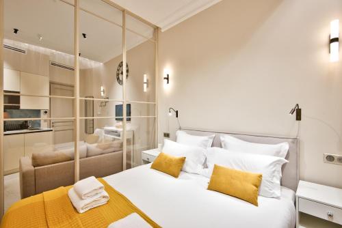 a bedroom with a large white bed with yellow pillows at Aparthotel 9 ALBERTI Nice Centre in Nice