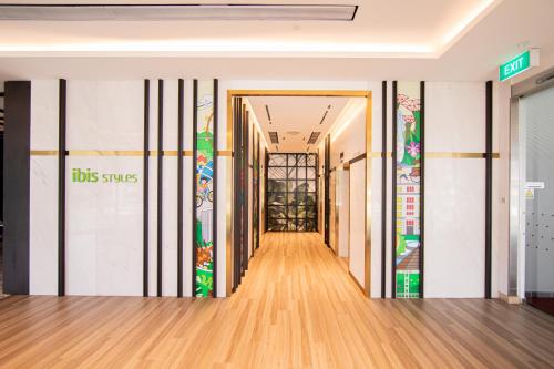 a corridor in a building with airus sign on the wall at ibis Styles Singapore Albert in Singapore